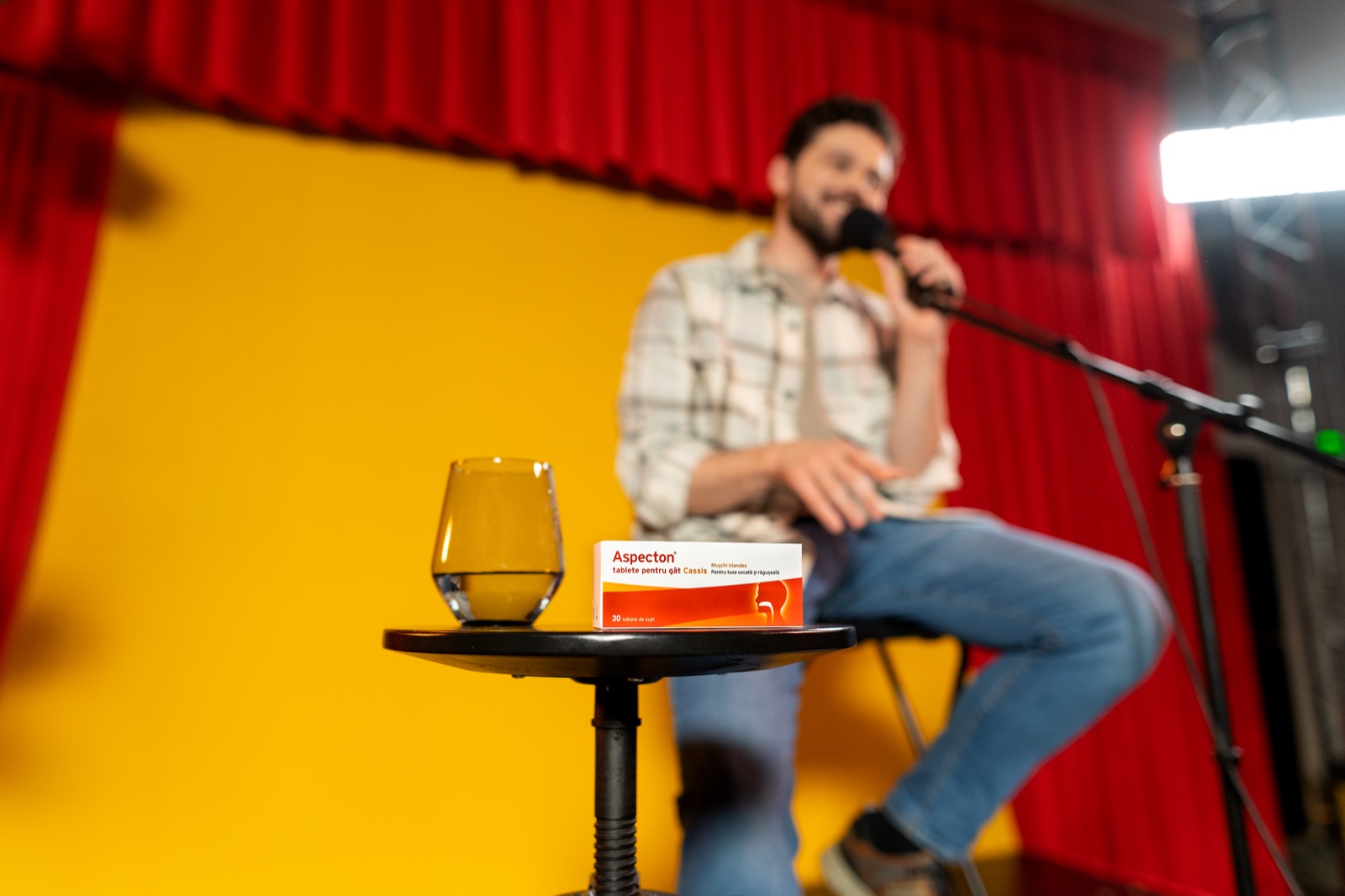 Aspecton Cassis throat tablets on the stage table, the comic back at the mic behind them.