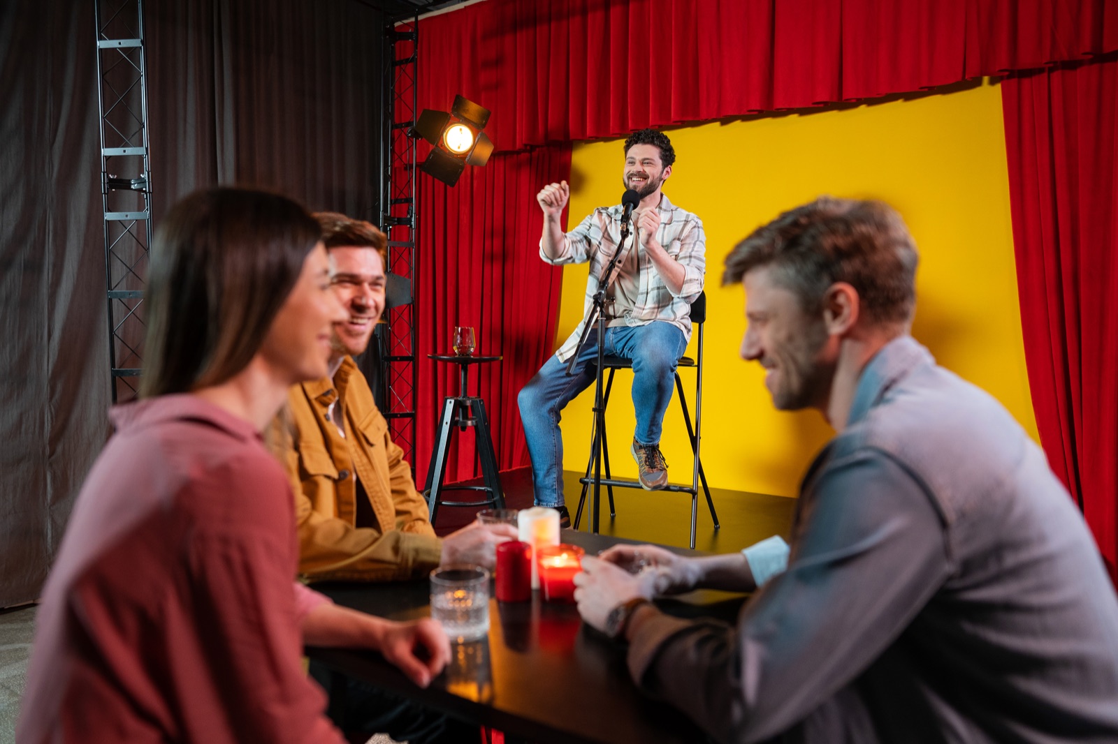 Key visual from the shoot day: the comic on stage, the front table already laughing.