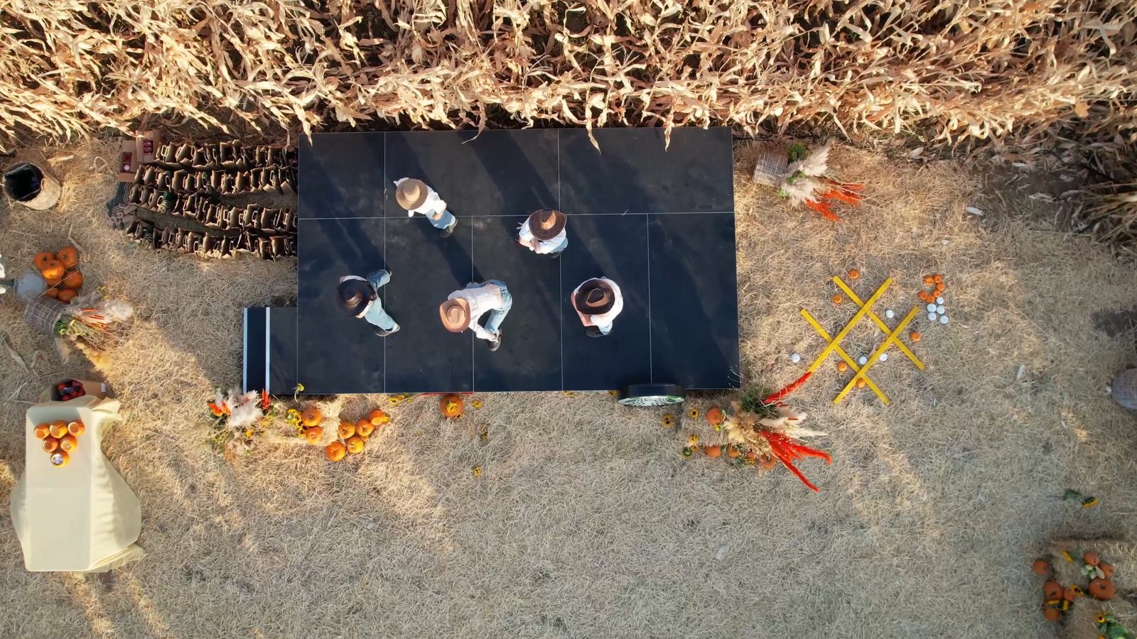 From above: the dancers on the stage in the clearing, with the corn wall behind them.