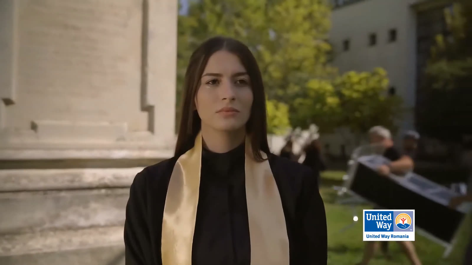 The graduate is left standing while the set is cleared around her.