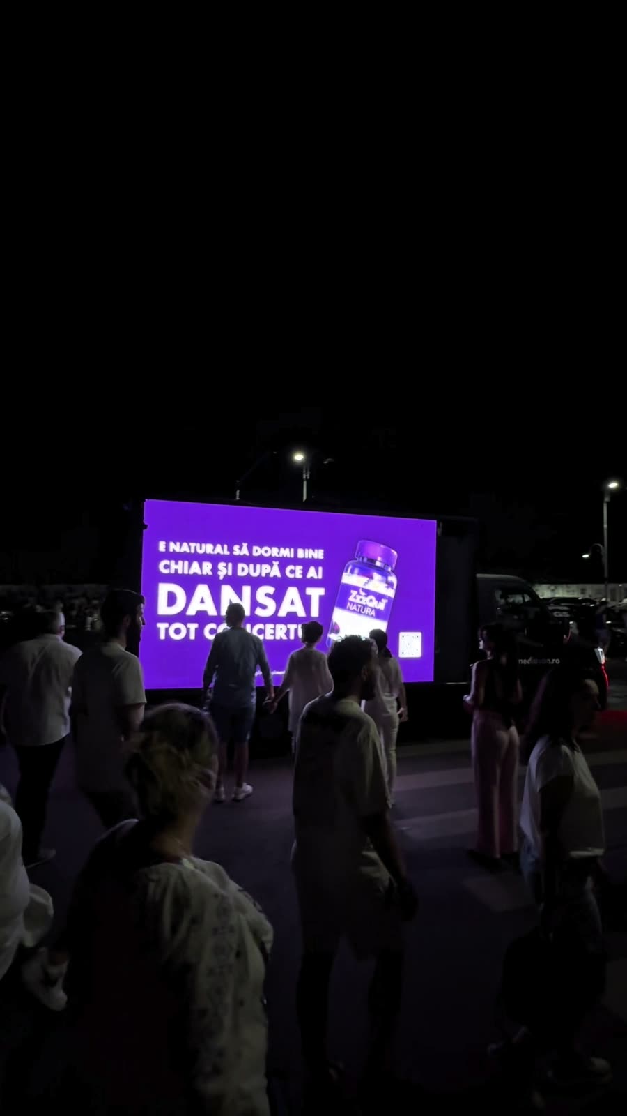 Concert night: the crowd heads out past the van's 'DANSAT TOT CONCERTUL' screen.