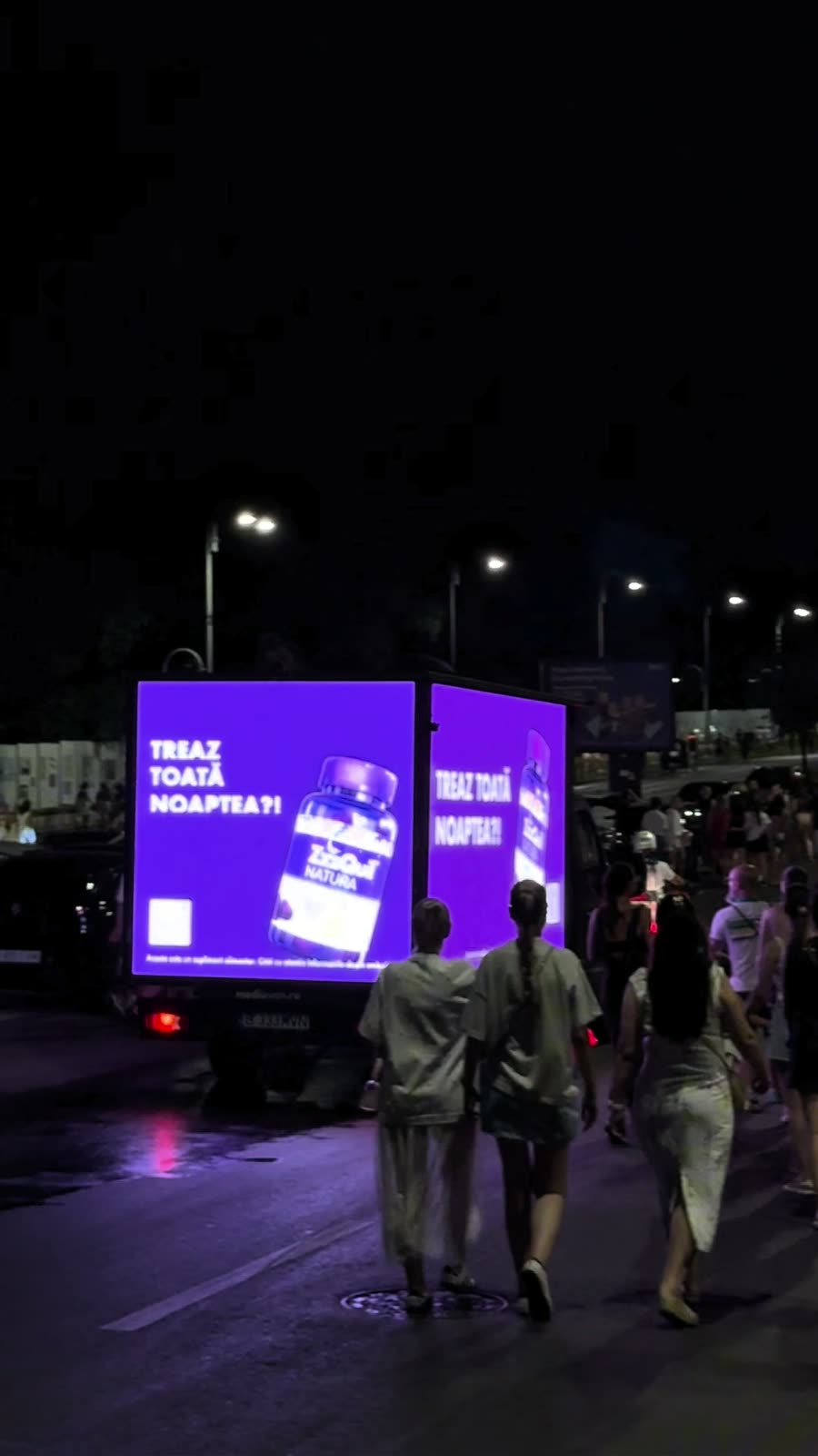 Concert night: 'TREAZ TOATĂ NOAPTEA?!' on the van as fans walk away from the venue.