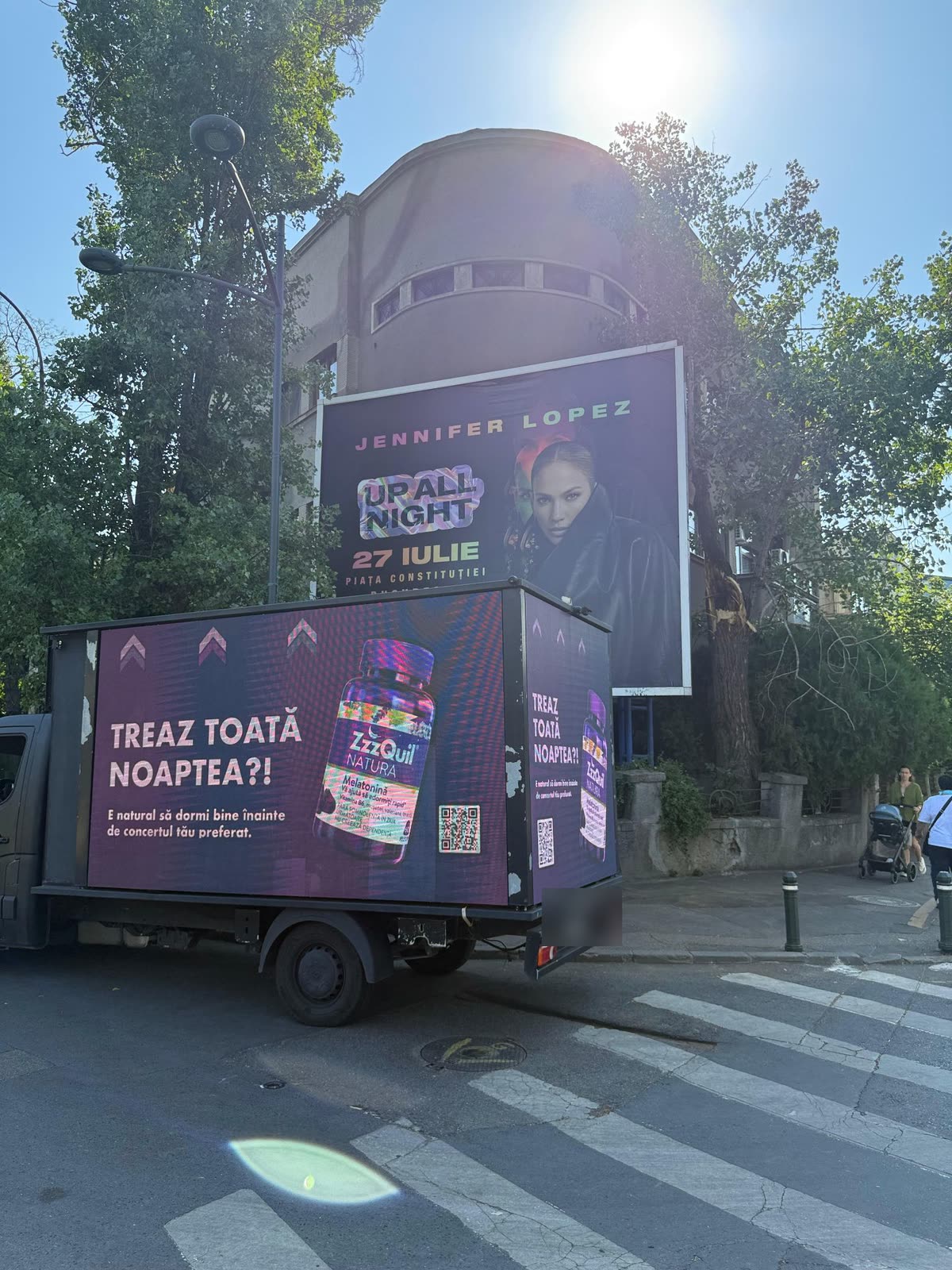 Before the concert, the van parked under a J.Lo billboard with 'TREAZ TOATĂ NOAPTEA?!' on its side.